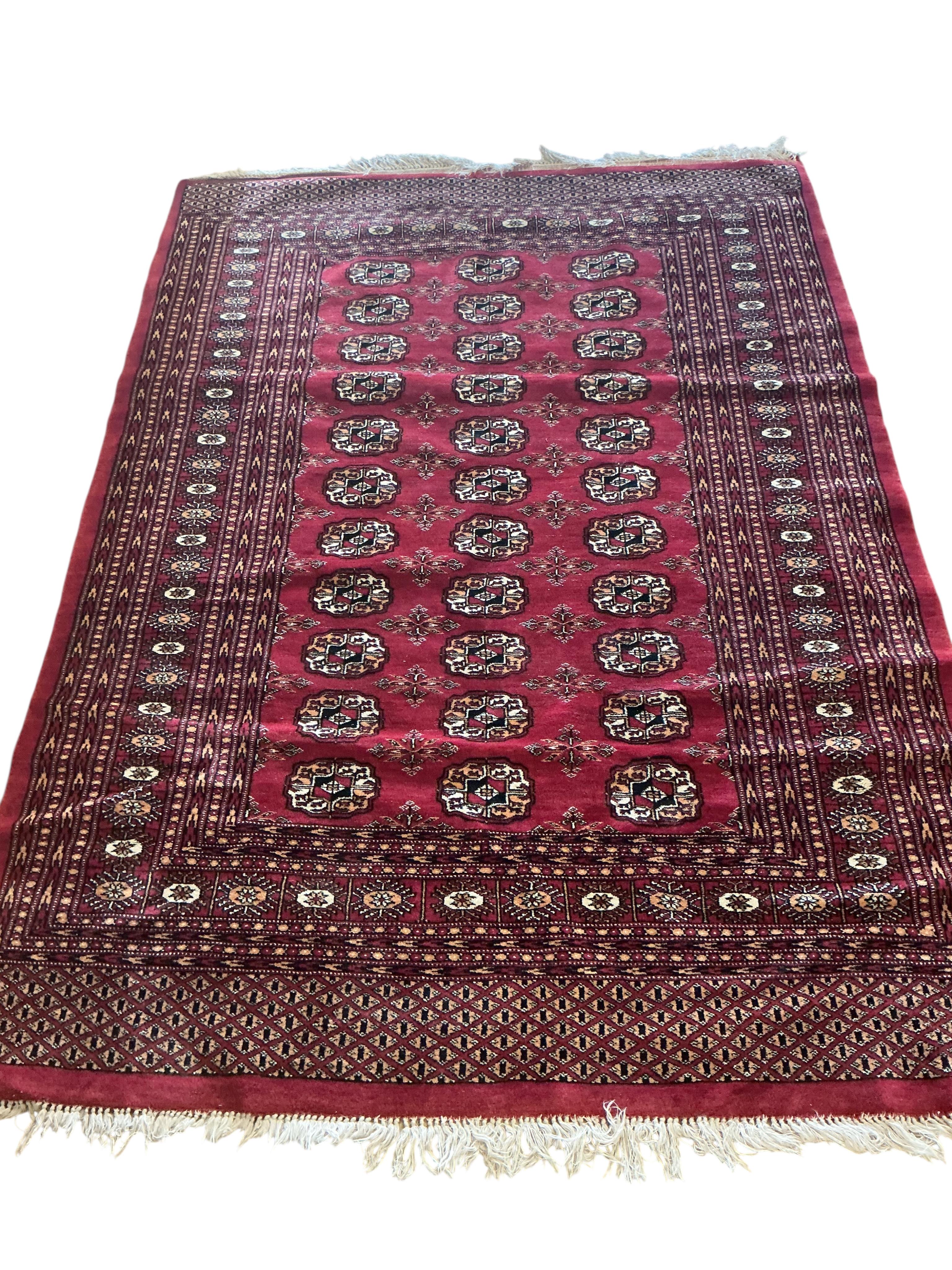 A Bokhara red ground rug, 180 x 130cm